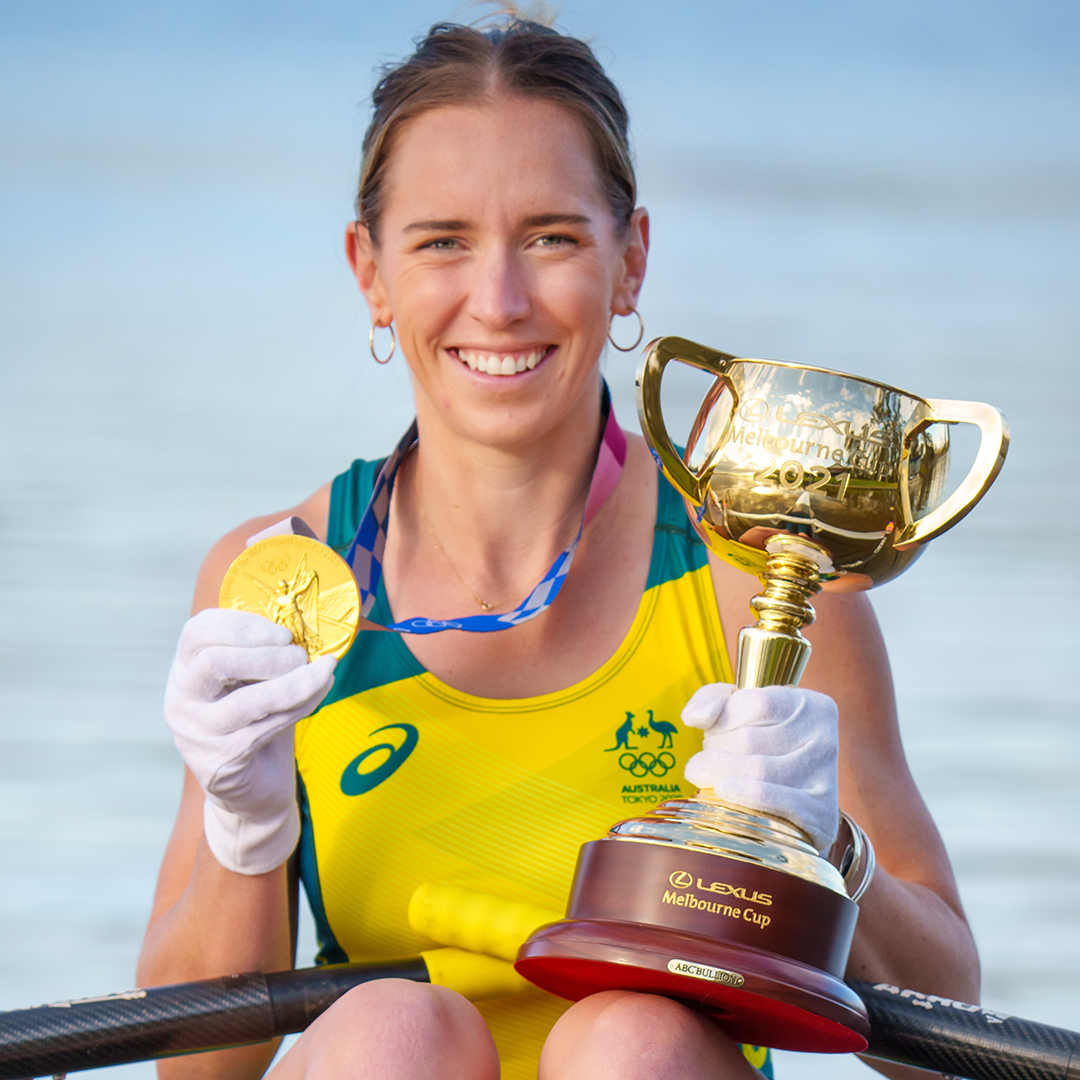 An Australian rowing Olympian holds the cup and her Gold medal.