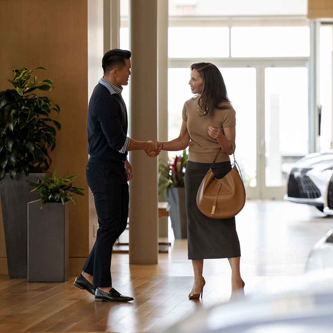 A Lexus Consultant greeting a guest in a dealership